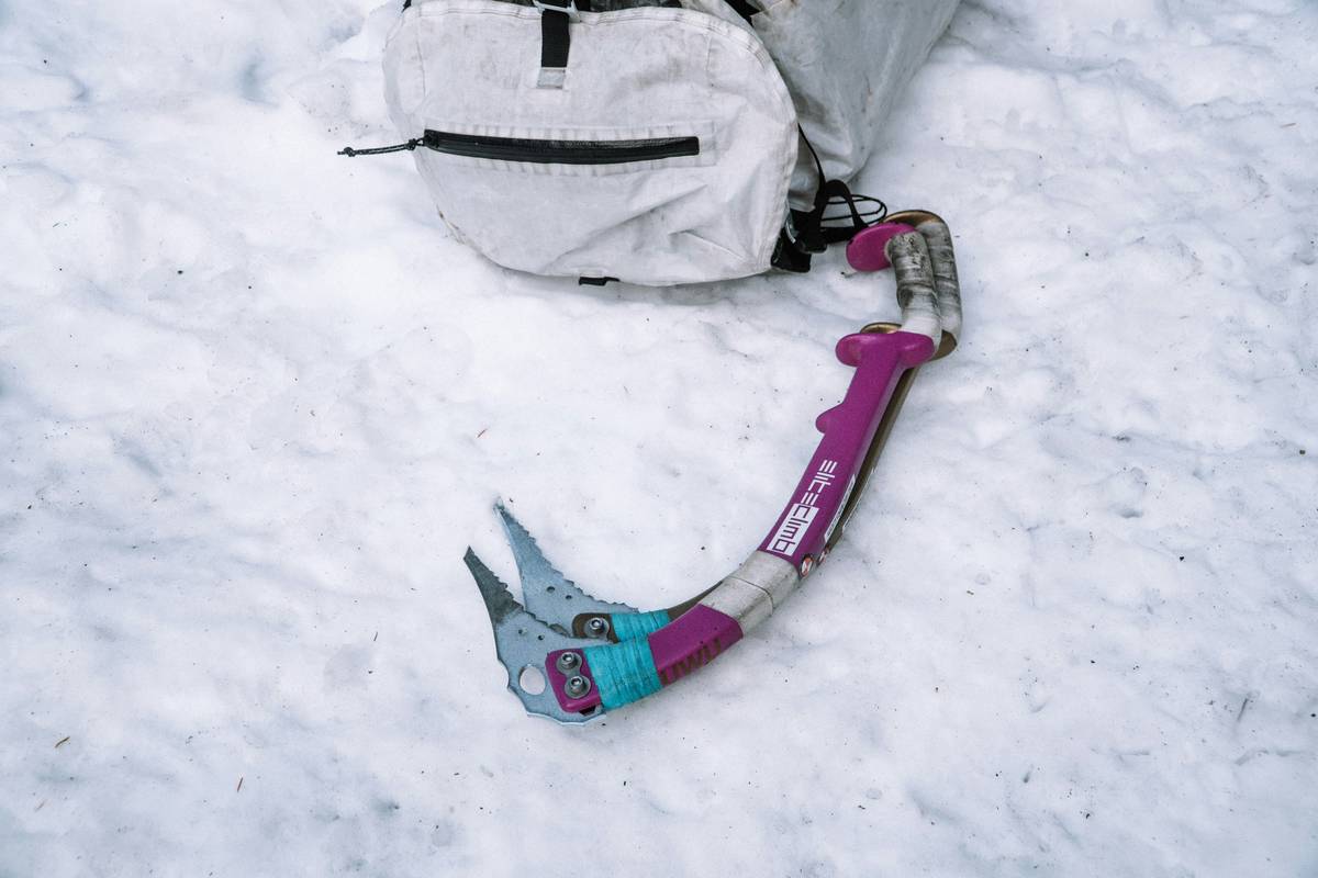 a pair of skis and a bag laying in the snow