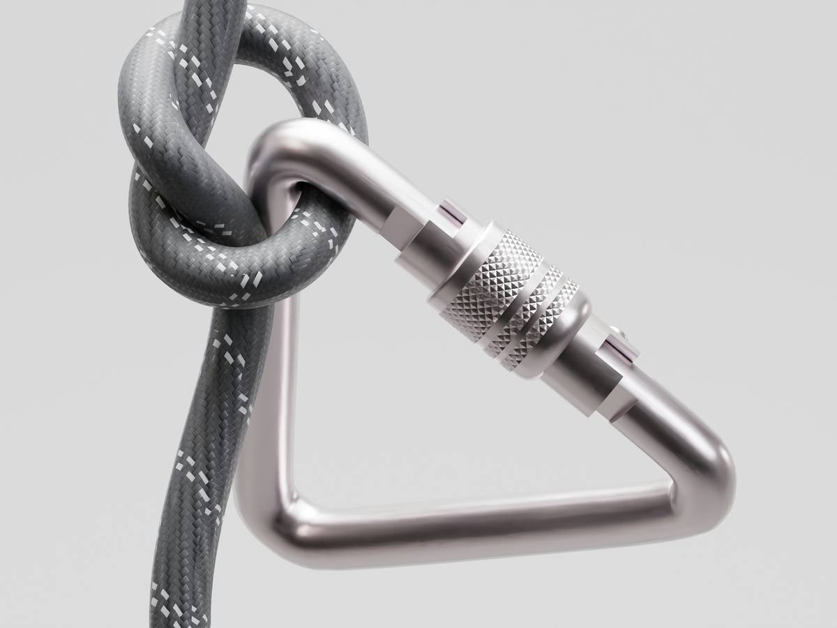 Proper route guard installation using nylon sling and dual locking carabiners on rock horn
