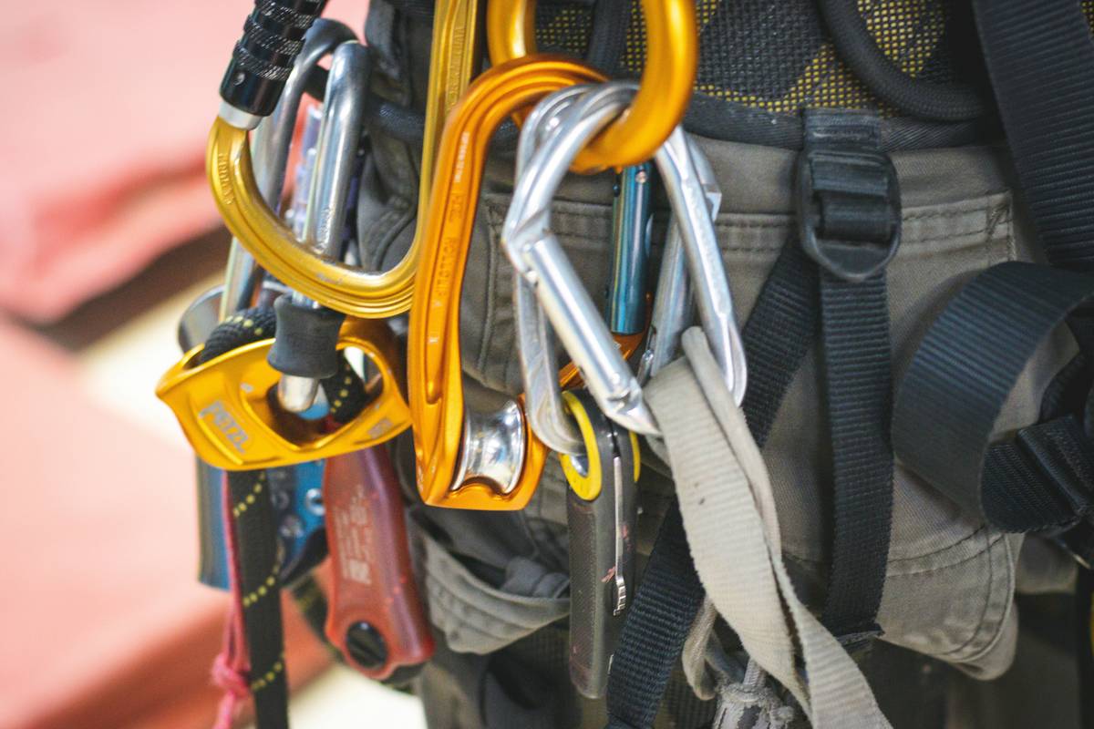 Close-up of hands inspecting climbing harness and webbing as part of climbing safety checklist