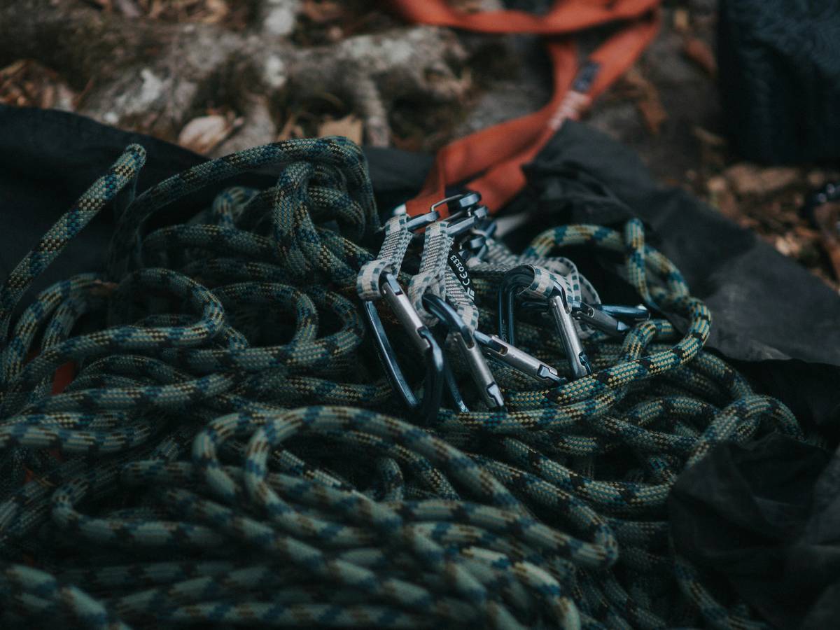 Close-up of worn climbing protection devices showing sling degradation and metal fatigue