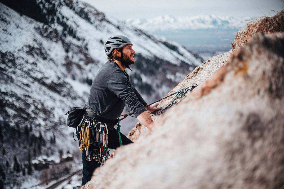 Climber placing critical route guard tip on multi-pitch trad climb