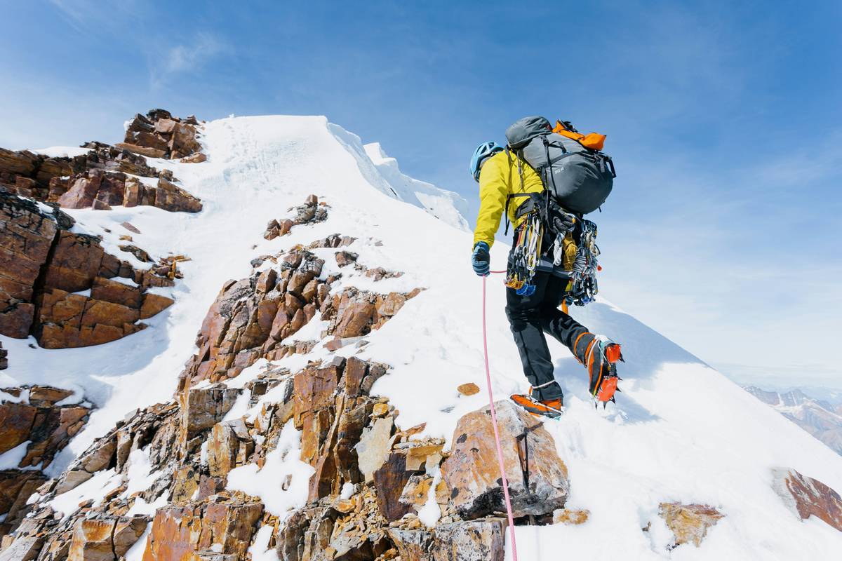 Climber placing route guard brands in steep trad crack