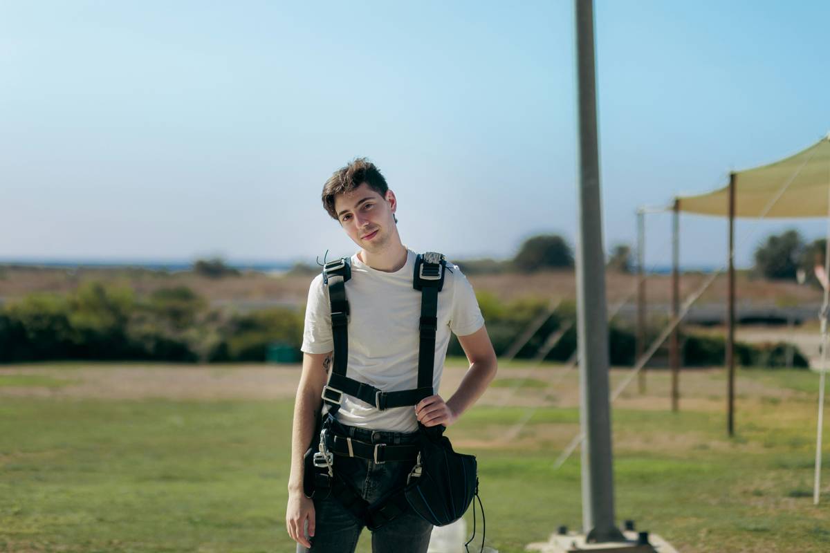 a young man standing in a field with a camera