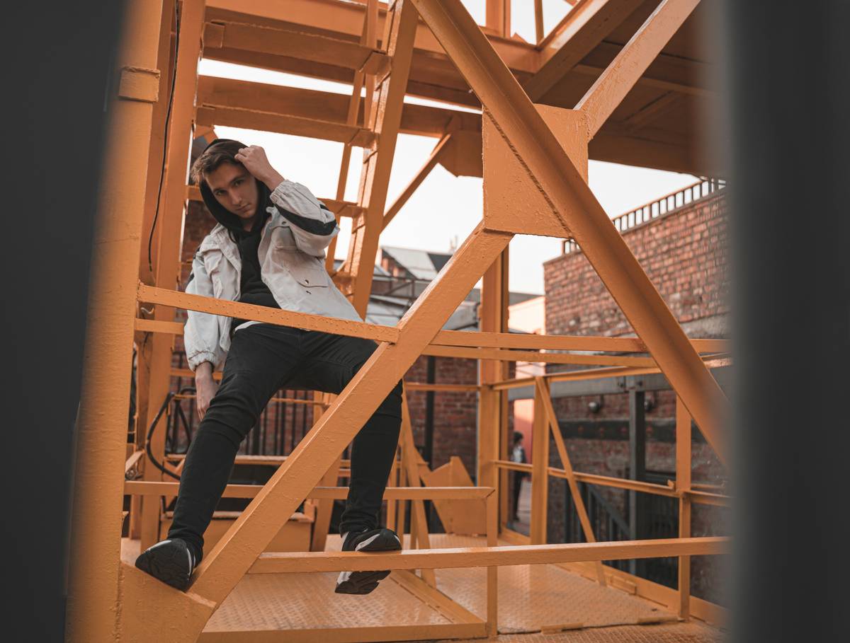 woman in blue denim jacket and black pants sitting on brown wooden ladder