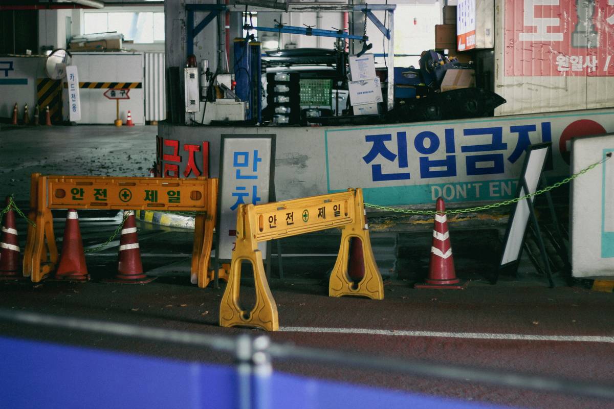 Yellow barriers and orange cones block an area